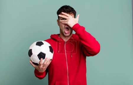 Photo for Adult man looking shocked, scared or terrified, covering face with hand. soccer and sport concept - Royalty Free Image