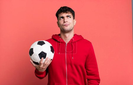 Photo for Adult man shrugging, feeling confused and uncertain. soccer and sport concept - Royalty Free Image