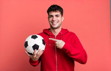 Photo for Adult man smiling cheerfully, feeling happy and pointing to the side. soccer and sport concept - Royalty Free Image