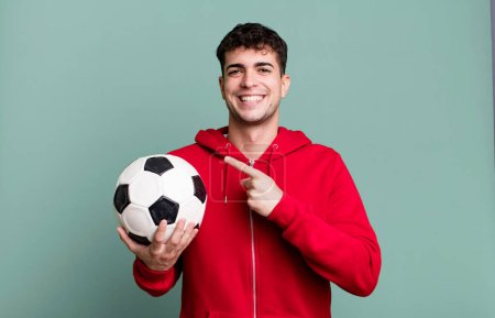 Photo for Adult man looking excited and surprised pointing to the side. soccer and sport concept - Royalty Free Image