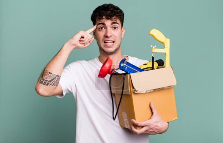 Photo for Adult man feeling confused and puzzled, showing you are insane with a toolbox. housekeeper concept - Royalty Free Image