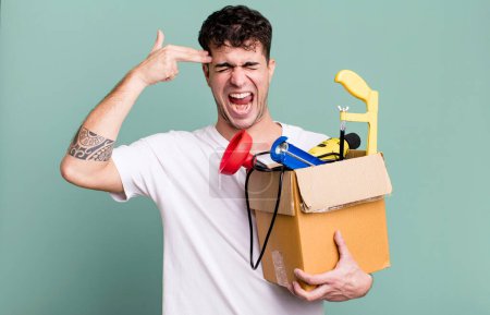 Photo for Adult man looking unhappy and stressed, suicide gesture making gun sign with a toolbox. housekeeper concept - Royalty Free Image