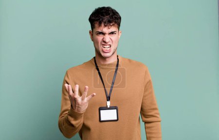 Téléchargez les photos : Homme adulte regardant en colère, ennuyé et frustré avec une carte d'identité d'accès - en image libre de droit