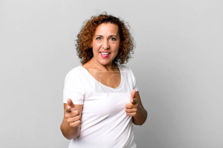Photo for Middle age hispanic woman feeling happy, cool, satisfied, relaxed and successful, pointing at camera, choosing you - Royalty Free Image
