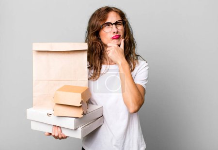 Photo for Hispanic pretty woman thinking, feeling doubtful and confused. take away fast food packages concept - Royalty Free Image
