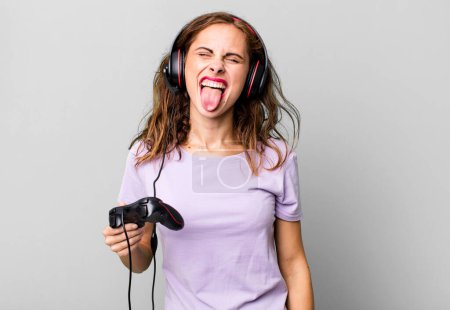Photo for Hispanic pretty woman with cheerful and rebellious attitude, joking and sticking tongue out. gamer concept - Royalty Free Image