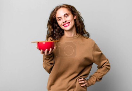 Photo for Hispanic pretty woman smiling happily with a hand on hip and confident - Royalty Free Image