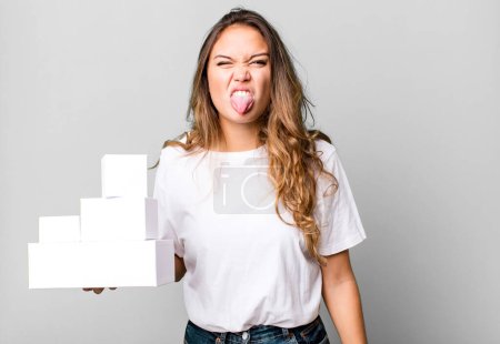 Photo for Hispanic pretty woman feeling disgusted and irritated and tongue out with white boxes packages - Royalty Free Image