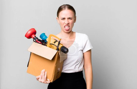Foto de Caucasian pretty woman feeling disgusted and irritated and tongue out with a tool box. repair home concept - Imagen libre de derechos