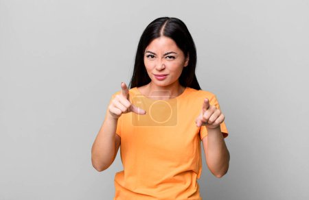 Foto de Pretty latin woman pointing forward at camera with both fingers and angry expression, telling you to do your duty - Imagen libre de derechos
