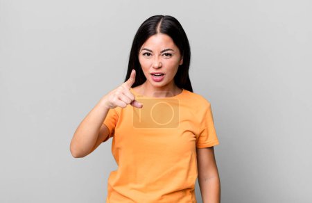 Photo for Pretty latin woman pointing at camera with an angry aggressive expression looking like a furious, crazy boss - Royalty Free Image