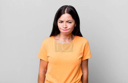 Photo for Pretty latin woman with a goofy, crazy, surprised expression, puffing cheeks, feeling stuffed, fat and full of food - Royalty Free Image