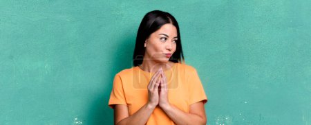 Photo for Pretty latin woman feeling proud, mischievous and arrogant while scheming an evil plan or thinking of a trick - Royalty Free Image