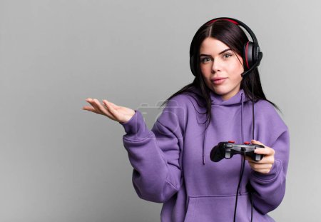 Foto de Mujer joven con auriculares jugando videojuego en joystick - Imagen libre de derechos