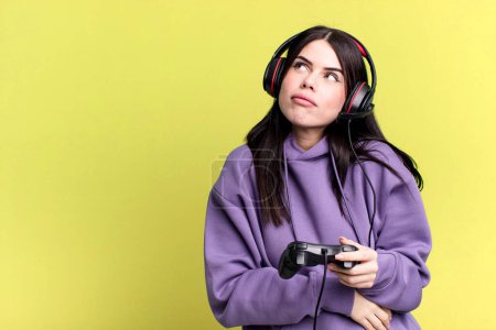 Foto de Mujer joven con auriculares jugando videojuego en joystick - Imagen libre de derechos