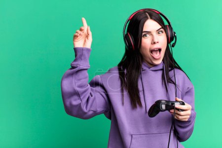 Photo for Young woman wearing headphones playing video game on joystick - Royalty Free Image