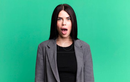 Photo for Young adult pretty woman looking very shocked or surprised, staring with open mouth saying wow - Royalty Free Image
