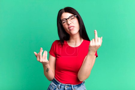 Photo for Young adult pretty woman feeling provocative, aggressive and obscene, flipping the middle finger, with a rebellious attitude - Royalty Free Image