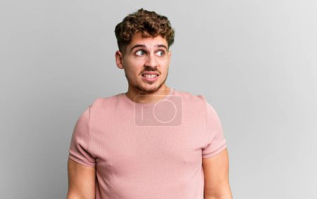 Photo for Young adult caucasian man looking worried, stressed, anxious and scared, panicking and clenching teeth - Royalty Free Image