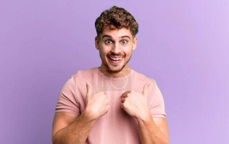 Photo for Young adult caucasian man feeling happy, surprised and proud, pointing to self with an excited, amazed look - Royalty Free Image