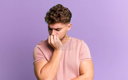 Téléchargez les photos : Young adult caucasian man feeling serious, thoughtful and concerned, staring sideways with hand pressed against chin - en image libre de droit