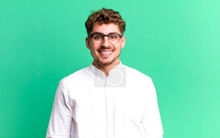 Téléchargez les photos : Young adult caucasian man looking happy and goofy with a broad, fun, loony smile and eyes wide open - en image libre de droit