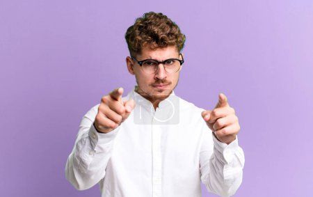 Photo for Young adult caucasian man pointing forward at camera with both fingers and angry expression, telling you to do your duty - Royalty Free Image