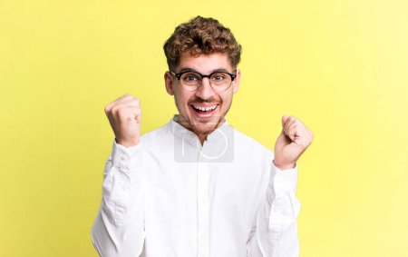 Photo for Young adult caucasian man feeling happy, surprised and proud, shouting and celebrating success with a big smile - Royalty Free Image