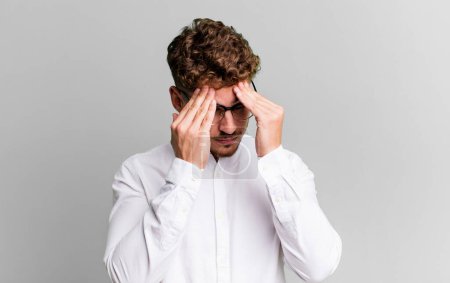 Foto de Young adult caucasian man looking stressed and frustrated, working under pressure with a headache and troubled with problems - Imagen libre de derechos