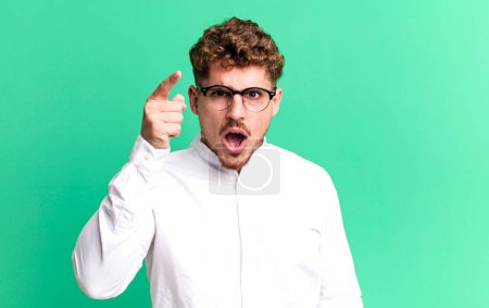 Photo for Young adult caucasian man pointing at camera with an angry aggressive expression looking like a furious, crazy boss - Royalty Free Image