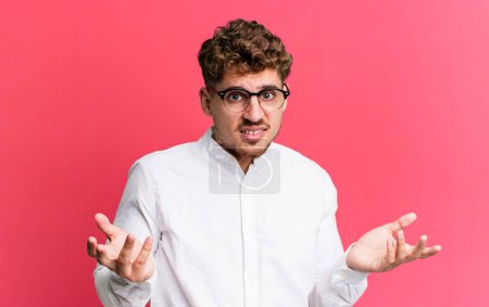 Photo for Young adult caucasian man feeling clueless and confused, not sure which choice or option to pick, wondering - Royalty Free Image