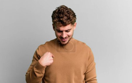 Téléchargez les photos : Young adult caucasian man smiling cheerfully and casually, looking downwards and pointing to chest - en image libre de droit