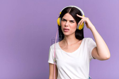 Foto de Sintiéndose confundido y perplejo, mostrando que estás loco. escuchar música qith a auriculares - Imagen libre de derechos