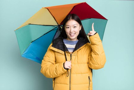 Téléchargez les photos : Jeune adulte jolie femme asiatique portant anorak et un parapluie. concept hiver et froid - en image libre de droit