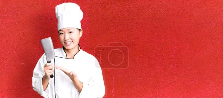 Téléchargez les photos : Jeune adulte jolie femme asiatique. chef de restaurant avec un couteau - en image libre de droit