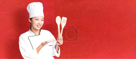 Téléchargez les photos : Jeune adulte jolie femme asiatique. chef de restaurant avec un outil en bois - en image libre de droit