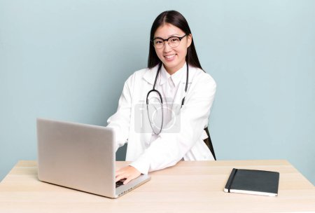 Foto de Joven adulto bastante asiático médico mujer en un escritorio con un portátil - Imagen libre de derechos