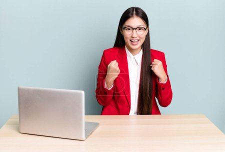 Téléchargez les photos : Pretty asian woman feeling shocked,laughing and celebrating success. business desk concept - en image libre de droit