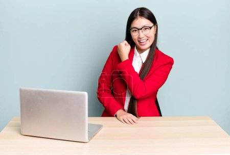Photo for Pretty asian woman feeling happy and facing a challenge or celebrating. business desk concept - Royalty Free Image