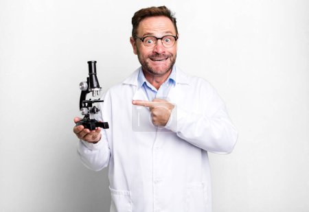 Photo for Middle age man looking excited and surprised pointing to the side. scientist concept - Royalty Free Image