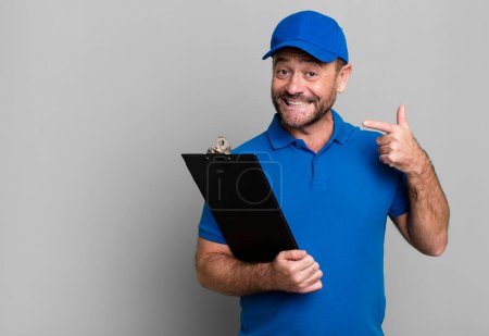 Photo for Middle age man smiling confidently pointing to own broad smile. company employee with an inventory - Royalty Free Image