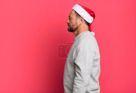 Foto de Hombre de mediana edad en vista de perfil pensando, imaginando o soñando despierto. concepto de Navidad - Imagen libre de derechos