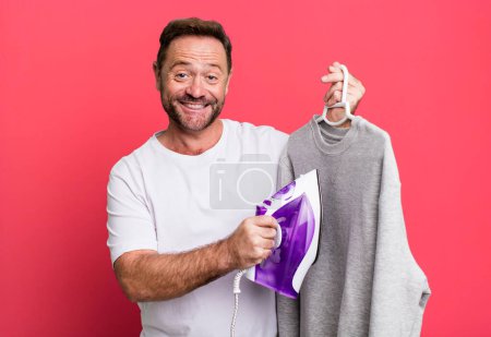 Photo for Middle age man with an iron hand and a cloth sport coach concept with a soccer ball - Royalty Free Image
