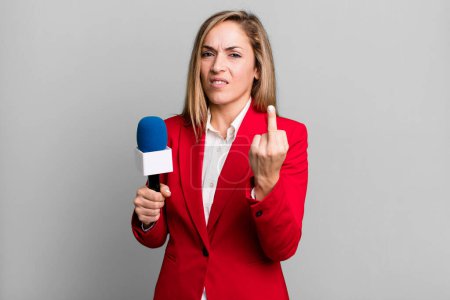 Téléchargez les photos : Pretty blonde woman feeling angry, annoyed, rebellious and aggressive. presenter with a microphone concept - en image libre de droit