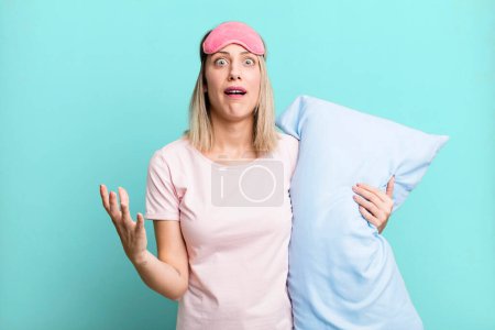 Photo for Pretty blonde woman looking desperate, frustrated and stressed. pajamas and nightwear concept - Royalty Free Image