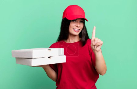 Photo for Hispanic pretty woman smiling and looking friendly, showing number one. delivery pizza concept - Royalty Free Image