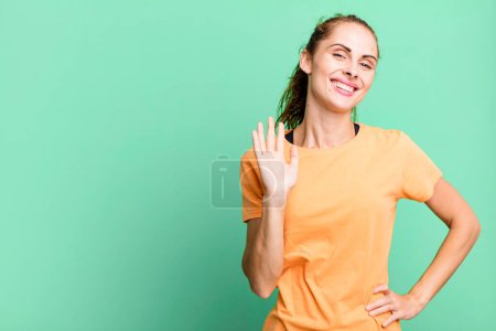 Photo for Hispanic pretty woman smiling happily, waving hand, welcoming and greeting you. copy space concept - Royalty Free Image