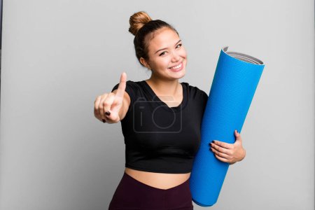 Photo for Hispanic pretty woman smiling proudly and confidently making number one. fitness and yoga concept - Royalty Free Image
