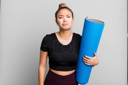 Photo for Hispanic pretty woman feeling sad and whiney with an unhappy look and crying. fitness and yoga concept - Royalty Free Image