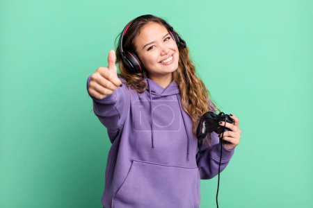 Photo for Hispanic pretty woman feeling proud,smiling positively with thumbs up. gamer concept - Royalty Free Image